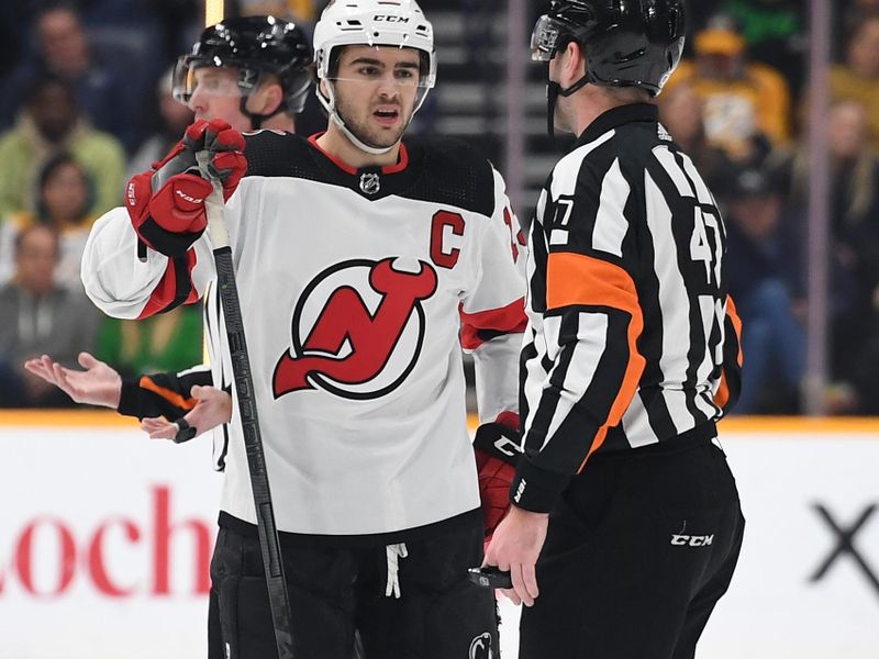 Jan 26, 2023; Nashville, Tennessee, USA; New Jersey Devils center Nico Hischier (13) talks with referee Carter Sandlak (47) after a penalty call during the first period against the Nashville Predators at Bridgestone Arena. Mandatory Credit: Christopher Hanewinckel-USA TODAY Sports