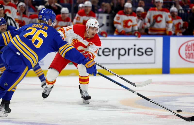 Nov 9, 2024; Buffalo, New York, USA;  Buffalo Sabres defenseman Rasmus Dahlin (26) tries to block a pass by Calgary Flames center Mikael Backlund (11) during the first period at KeyBank Center. Mandatory Credit: Timothy T. Ludwig-Imagn Images