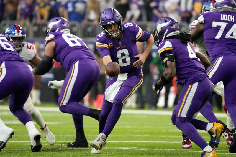 Minnesota Vikings quarterback Kirk Cousins (8) hands the ball off to running back Dalvin Cook (4) during the first half of an NFL wild card playoff football game New York Giants, Sunday, Jan. 15, 2023, in Minneapolis. (AP Photo/Charlie Neibergall)