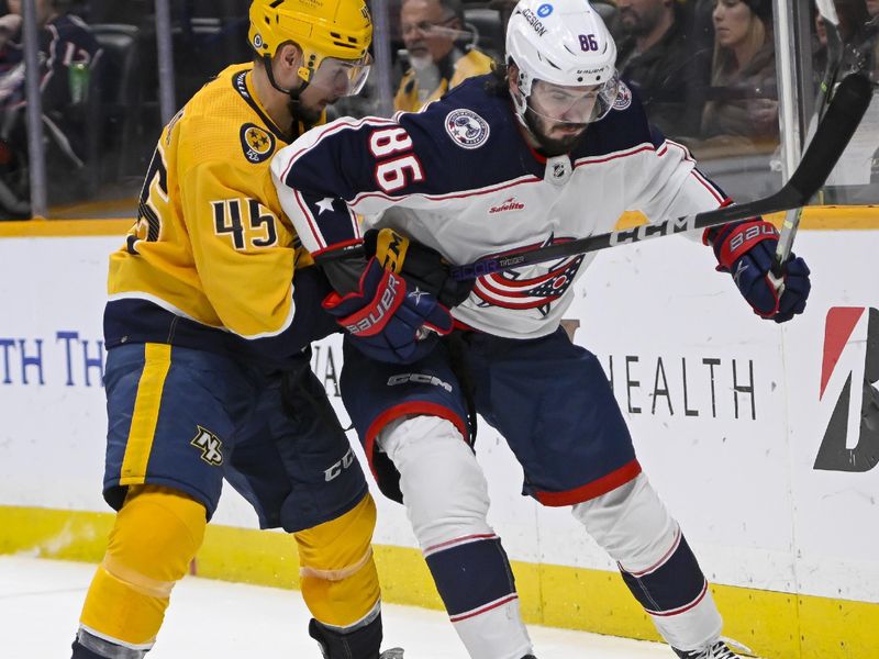 Jan 17, 2023; Nashville, Tennessee, USA;  Columbus Blue Jackets right wing Kirill Marchenko (86) and Nashville Predators defenseman Alexandre Carrier (45) fight for the puck during the second period at Bridgestone Arena. Mandatory Credit: Steve Roberts-USA TODAY Sports