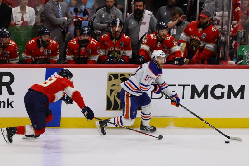 Jun 10, 2024; Sunrise, Florida, USA; Edmonton Oilers forward Connor McDavid (97) controls the puck against Florida Panthers forward Steven Lorentz (18) during the first period in game two of the 2024 Stanley Cup Final at Amerant Bank Arena. Mandatory Credit: Sam Navarro-USA TODAY Sports