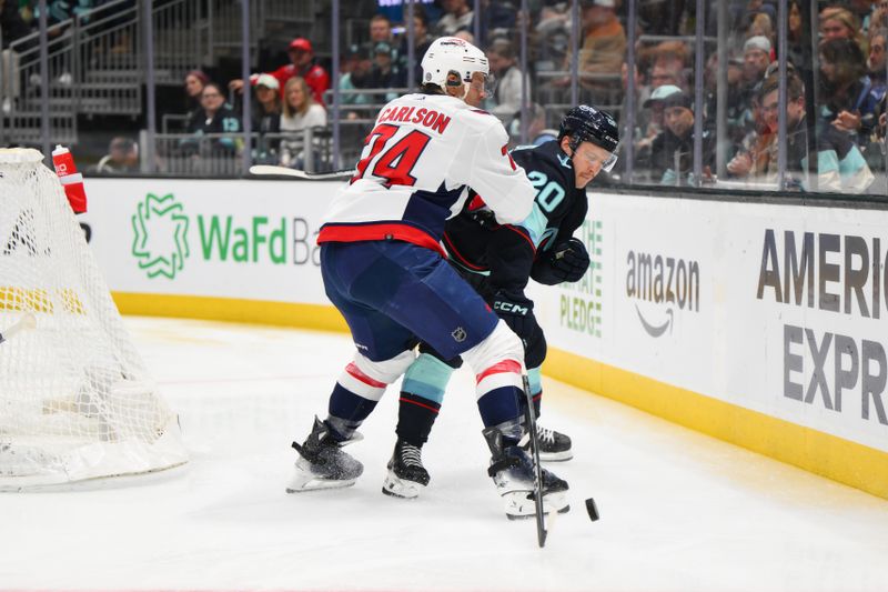 Mar 14, 2024; Seattle, Washington, USA; Washington Capitals defenseman John Carlson (74) and Seattle Kraken right wing Eeli Tolvanen (20) play the puck during the second period at Climate Pledge Arena. Mandatory Credit: Steven Bisig-USA TODAY Sports