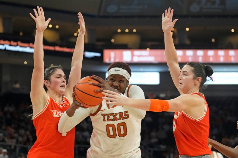 Dec 29, 2024; Austin, Texas, USA; Texas Longhorns center Kyla Oldacre (00) drives to the basket between Rio Grande Valley Vaqueros forward Charlotte O'Keefe (1) and guard  and Kade Hackeroff (5) during the first half at Moody Center. Mandatory Credit: Scott Wachter-Imagn Images