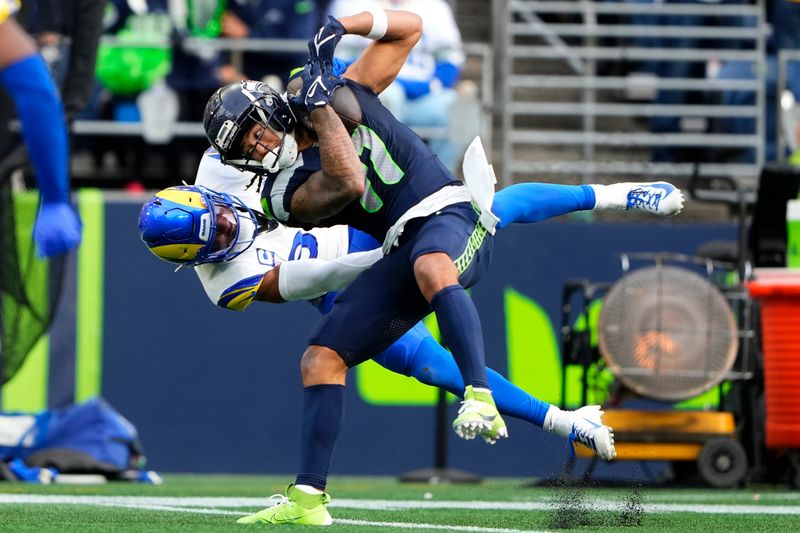 Seattle Seahawks wide receiver Jaxon Smith-Njigba, right, catches a pass against Los Angeles Rams safety Quentin Lake during the first half of an NFL football game in Seattle, Sunday, Nov. 3, 2024. (AP Photo/Lindsey Wasson)