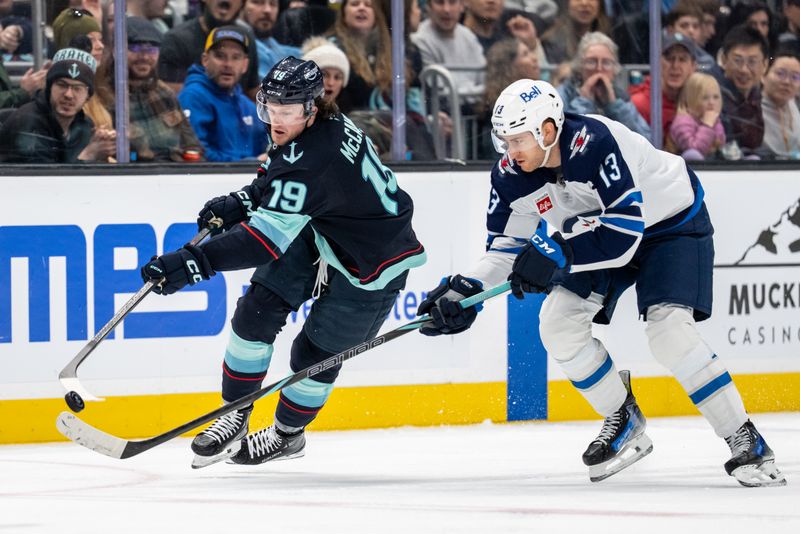 Mar 16, 2025; Seattle, Washington, USA;  Seattle Kraken forward Jared McCann (19) and Winnipeg Jets forward Gabriel Vilardi (13) battle for the puck during the third period at Climate Pledge Arena. Mandatory Credit: Stephen Brashear-Imagn Images
