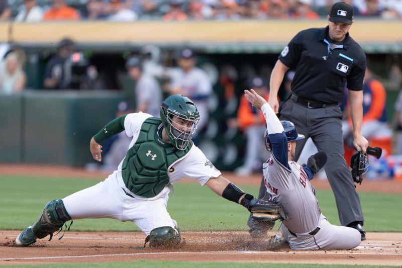 Jul 23, 2024; Oakland, California, USA;  Oakland Athletics catcher Shea Langeliers (23) tags out Houston Astros third base Alex Bregman (2) during the first inning at Oakland-Alameda County Coliseum. Mandatory Credit: Stan Szeto-USA TODAY Sports