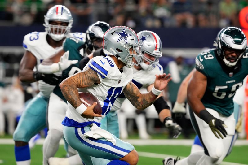 Dallas Cowboys quarterback Trey Lance runs the ball under pressure from Philadelphia Eagles defensive tackle Thomas Booker IV (59) in the second half of an NFL football game in Arlington, Texas, Sunday, Nov. 10, 2024. (AP Photo/Jeffrey McWhorter)