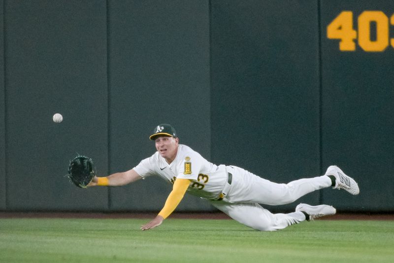 May 9, 2025; West Sacramento, California, USA; Athletics outfielder JJ Bleday (33) attempts a diving catch against the New York Yankees during the fifth inning at Sutter Health Park. Mandatory Credit: Ed Szczepanski-Imagn Images