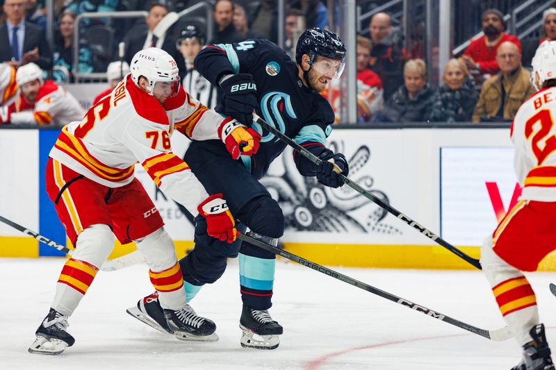 Oct 19, 2024; Seattle, Washington, USA; Seattle Kraken defenseman Jamie Oleksiak (24) shoots as Calgary Flames center Martin Pospisil (76) defends during the first period at Climate Pledge Arena. Mandatory Credit: Caean Couto-Imagn Images