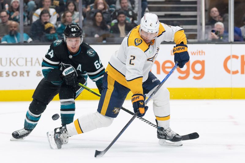 Feb 24, 2024; San Jose, California, USA; Nashville Predators defenseman Luke Schenn (2) attempts to gain control of the puck during the second period against San Jose Sharks center Mikael Granlund (64) at SAP Center at San Jose. Mandatory Credit: Stan Szeto-USA TODAY Sports