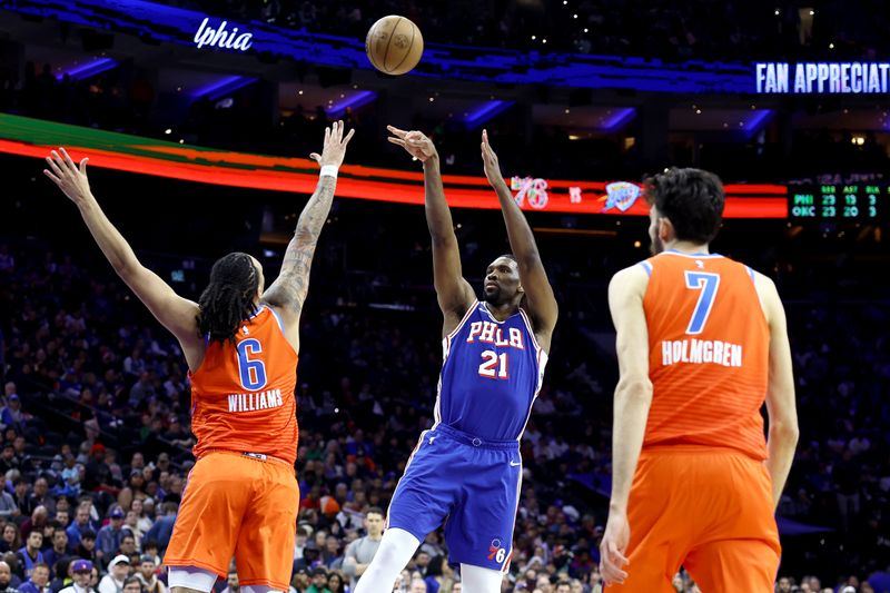 PHILADELPHIA, PENNSYLVANIA - APRIL 02: Joel Embiid #21 of the Philadelphia 76ers shoots between Luguentz Dort #5 and Chet Holmgren #7 of the Oklahoma City Thunder during the third quarter at the Wells Fargo Center on April 02, 2024 in Philadelphia, Pennsylvania. NOTE TO USER: User expressly acknowledges and agrees that, by downloading and or using this photograph, User is consenting to the terms and conditions of the Getty Images License Agreement. (Photo by Tim Nwachukwu/Getty Images)