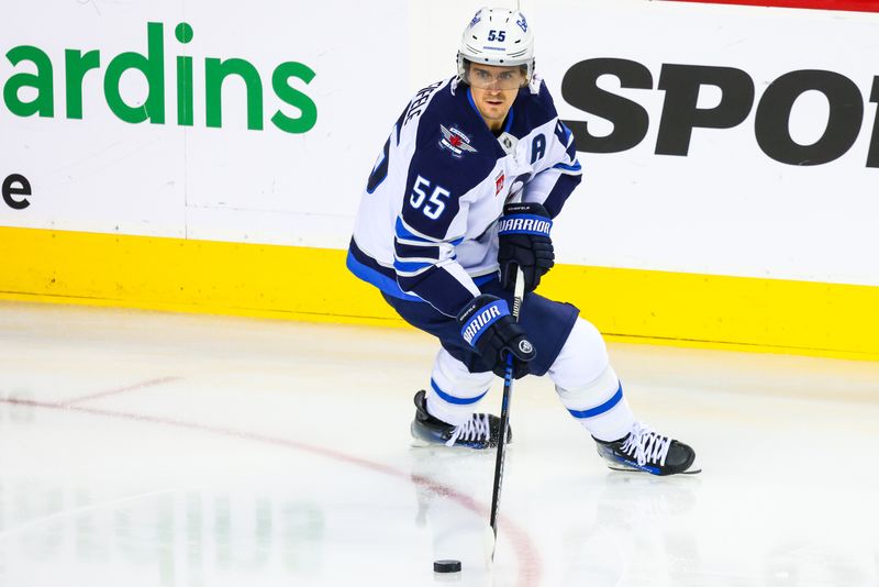 Oct 26, 2024; Calgary, Alberta, CAN; Winnipeg Jets center Mark Scheifele (55) controls the puck during the warmup period against the Calgary Flames at Scotiabank Saddledome. Mandatory Credit: Sergei Belski-Imagn Images