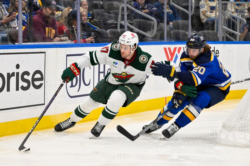 Nov 19, 2024; St. Louis, Missouri, USA;  Minnesota Wild defenseman Declan Chisholm (47) controls the puck as St. Louis Blues left wing Brandon Saad (20) defends during the second period at Enterprise Center. Mandatory Credit: Jeff Curry-Imagn Images