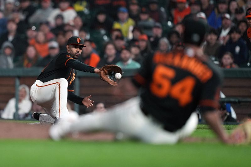 Jun 3, 2023; San Francisco, California, USA;  San Francisco Giants first baseman LaMonte Wade Jr. (left) catches a throw from relief pitcher Scott Alexander (54) during the eighth inning at Oracle Park. Mandatory Credit: Darren Yamashita-USA TODAY Sports