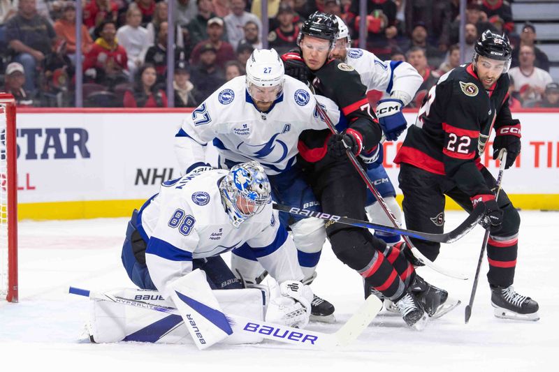 Oct 19, 2024; Ottawa, Ontario, CAN; Tampa Bay Lightning goalie Andrei Vasilevskiy (88) makes a save in front of Ottawa Senators left wing Brady Tkachuk (7) and right wing Michael Amadio (22) in the first period at the Canadian Tire Centre. Mandatory Credit: Marc DesRosiers-Imagn Images