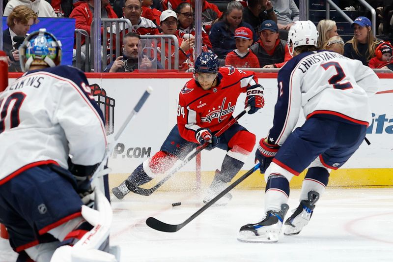 Nov 24, 2025; Washington, District of Columbia, USA; Washington Capitals right wing Justin Sourdif (34) skates with the puck against as Columbus Blue Jackets defenseman Jake Christiansen (2) defends during the third period at Capital One Arena. Mandatory Credit: Geoff Burke-Imagn Images