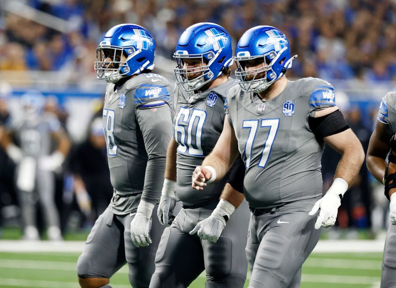 Detroit Lions offensive tackle Penei Sewell (58), guard Graham Glasgow (60) and center Frank Ragnow (77) during the first half of an NFL football game against the Minnesota Vikings Sunday, Jan. 7, 2024, in Detroit. (AP Photo/Duane Burleson)