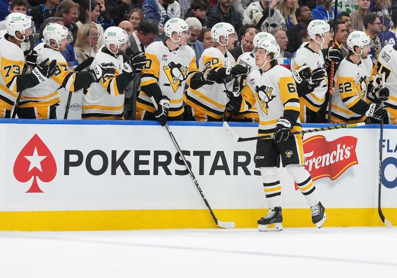 Apr 8, 2024; Toronto, Ontario, CAN; Pittsburgh Penguins right wing Rickard Rakell (67) celebrates at the bench after scoring a goal against the Toronto Maple Leafs during the first period at Scotiabank Arena. Mandatory Credit: Nick Turchiaro-USA TODAY Sports