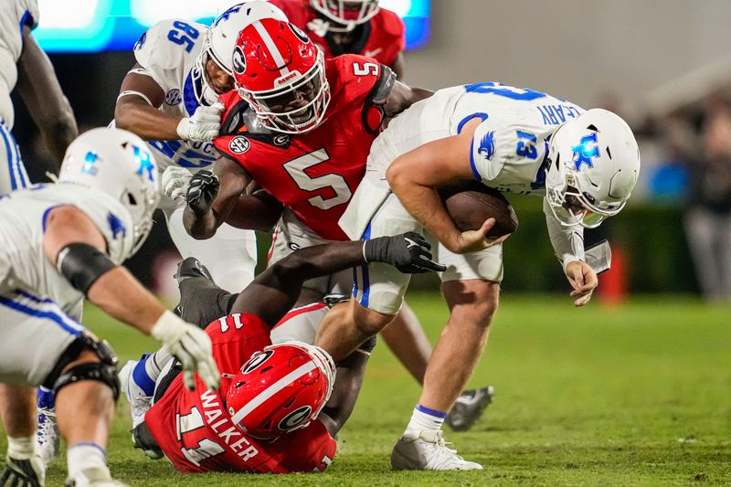 Oct 7, 2023; Athens, Georgia, USA; Kentucky Wildcats quarterback Devin Leary (13) is tackled by Georgia Bulldogs linebacker Jalon Walker (11) and linebacker Raylen Wilson (5) during the second half at Sanford Stadium. Mandatory Credit: Dale Zanine-USA TODAY Sports