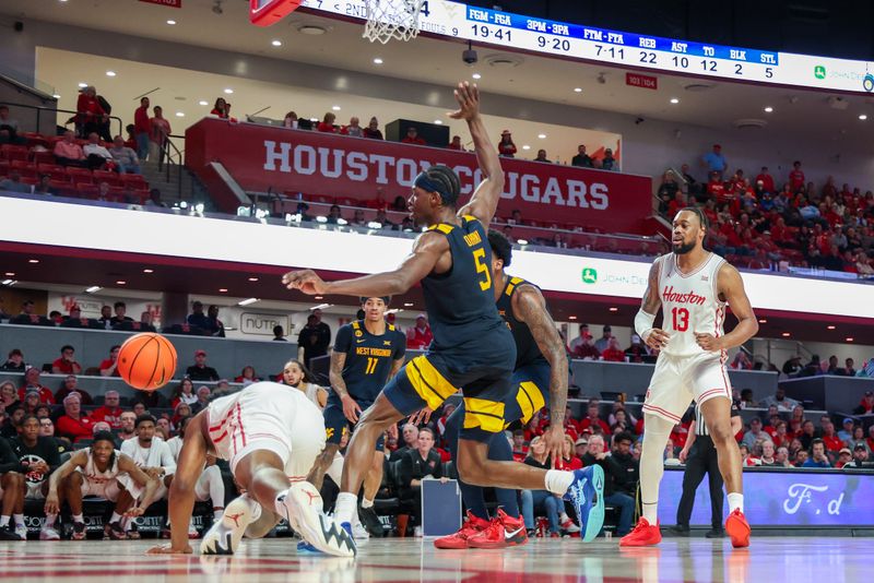 Jan 15, 2025; Houston, Texas, USA; Houston Cougars guard L.J. Cryer (4) is fouled by West Virginia Mountaineers guard Toby Okani (5) in the second half at Fertitta Center. Mandatory Credit: Thomas Shea-Imagn Images