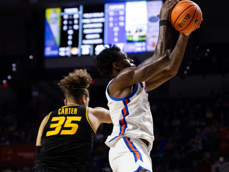 Feb 28, 2024; Gainesville, Florida, USA; Florida Gators forward Tyrese Samuel (4) grabs a rebound over Missouri Tigers forward Noah Carter (35) during the first half at Exactech Arena at the Stephen C. O'Connell Center. Mandatory Credit: Matt Pendleton-USA TODAY Sports