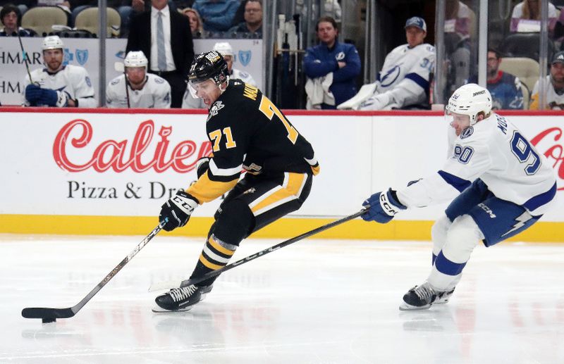 Nov 19, 2024; Pittsburgh, Pennsylvania, USA; Pittsburgh Penguins center Evgeni Malkin (71) skates with the puck as Tampa Bay Lightning defenseman J.J. Moser (90) chases during the third period at PPG Paints Arena. Mandatory Credit: Charles LeClaire-Imagn Images