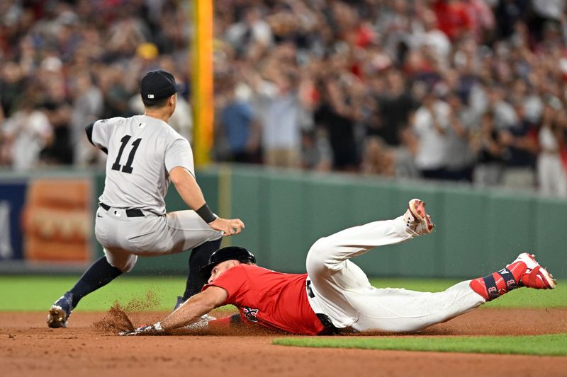 Jul 26, 2024; Boston, Massachusetts, USA; Boston Red Sox outfielder Wilyer Abreu (52) slides into second base against New York Yankees shortstop Anthony Volpe (11) after hitting a RBI double during the eighth inning at Fenway Park. Mandatory Credit: Brian Fluharty-USA TODAY Sports