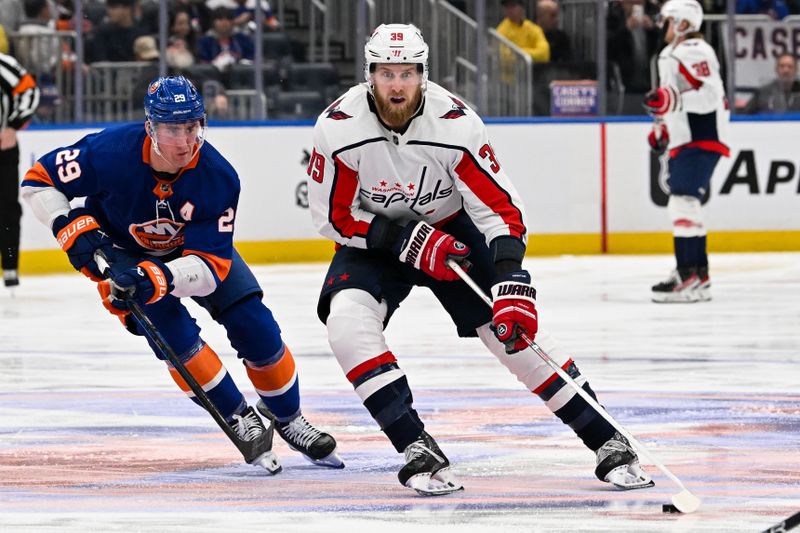 Dec 29, 2023; Elmont, New York, USA; Washington Capitals right wing Anthony Mantha (39) skate with the puck chased by New York Islanders center Brock Nelson (29)   during the third period at UBS Arena. Mandatory Credit: Dennis Schneidler-USA TODAY Sports