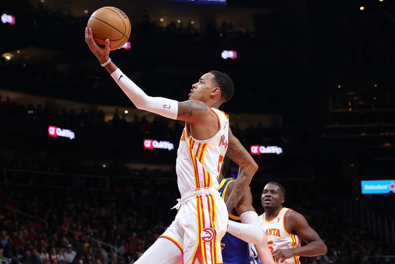 ATLANTA, GEORGIA - FEBRUARY 03:  Dejounte Murray #5 of the Atlanta Hawks drives against Jonathan Kuminga #00 of the Golden State Warriors during the second quarter at State Farm Arena on February 03, 2024 in Atlanta, Georgia.  NOTE TO USER: User expressly acknowledges and agrees that, by downloading and/or using this photograph, user is consenting to the terms and conditions of the Getty Images License Agreement.  (Photo by Kevin C. Cox/Getty Images)