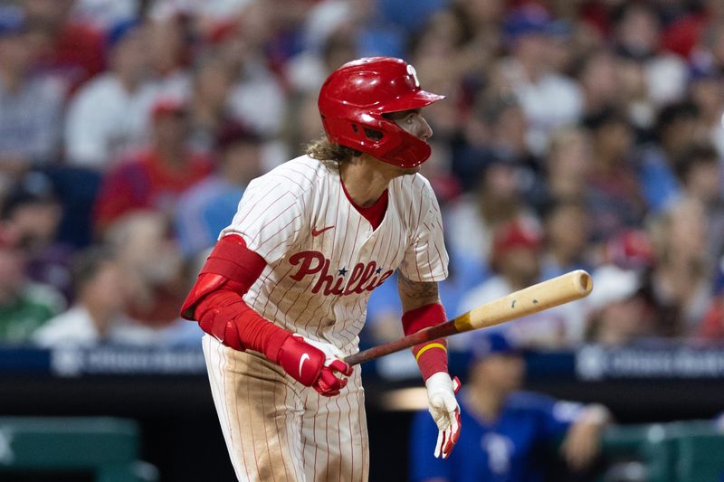 May 21, 2024; Philadelphia, Pennsylvania, USA; Philadelphia Phillies second base Bryson Stott (5) hits an RBI sacrifice fly during the eighth inning against the Texas Rangers at Citizens Bank Park. Mandatory Credit: Bill Streicher-USA TODAY Sports