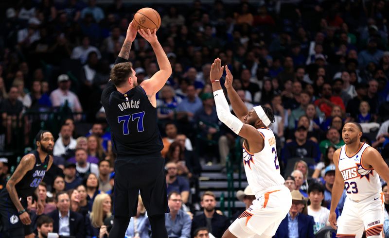 DALLAS, TX - FEBRUARY 22: Luka Doncic #77 of the Dallas Mavericks shoots the ball as Josh Okogie #2 of the Phoenix Suns defends in the first half at American Airlines Center on February 22, 2024 in Dallas, Texas. NOTE TO USER: User expressly acknowledges and agrees that, by downloading and or using this photograph, User is consenting to the terms and conditions of the Getty Images License Agreement. (Photo by Ron Jenkins/Getty Images)