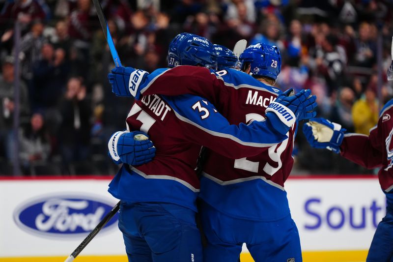 Nov 5, 2024; Denver, Colorado, USA; Colorado Avalanche center Casey Mittelstadt (37) and center Nathan MacKinnon (29) celebrate a goal scored in the second period against the Seattle Kraken at Ball Arena. Mandatory Credit: Ron Chenoy-Imagn Images