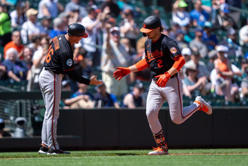 Jun 5, 2025; Seattle, Washington, USA;  Balitimore Orioles shortstop Gunnar Henderson (2) is congratulated by interim third base coach Buck Britton after hitting a solo home run during the sixth inning against the Seattle Mariners at T-Mobile Park. Mandatory Credit: Stephen Brashear-Imagn Images