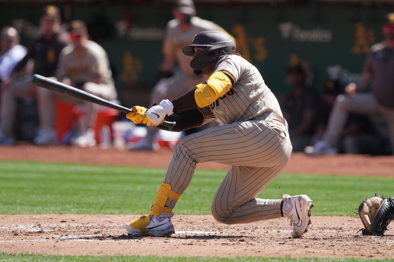 Sep 17, 2023; Oakland, California, USA; San Diego Padres catcher Luis Campusano (12) hits an RBI single against the Oakland Athletics during the fourth inning at Oakland-Alameda County Coliseum. Mandatory Credit: Darren Yamashita-USA TODAY Sports
