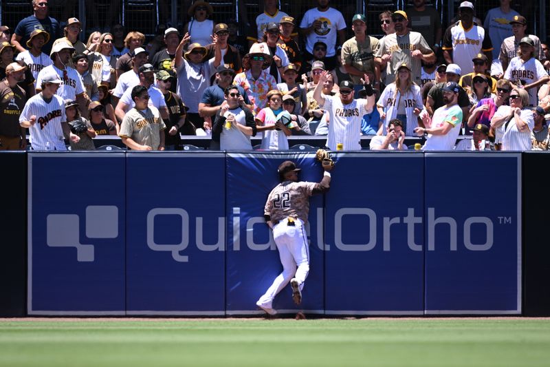 Jun 25, 2023; San Diego, California, USA; San Diego Padres left fielder Juan Soto (22) collides with the outfield wall after making a catch on a ball hit by Washington Nationals first baseman Dominic Smith (not pictured) during the second inning at Petco Park. Mandatory Credit: Orlando Ramirez-USA TODAY Sports