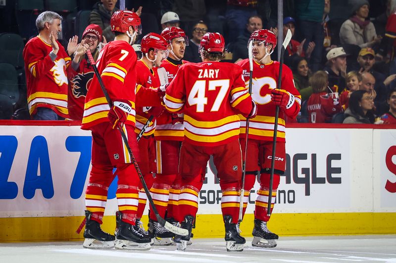 Jan 23, 2026; Calgary, Alberta, CAN; Calgary Flames center Morgan Frost (16) celebrates his goal with teammates against the Washington Capitals during the first period at Scotiabank Saddledome. Mandatory Credit: Sergei Belski-Imagn Images