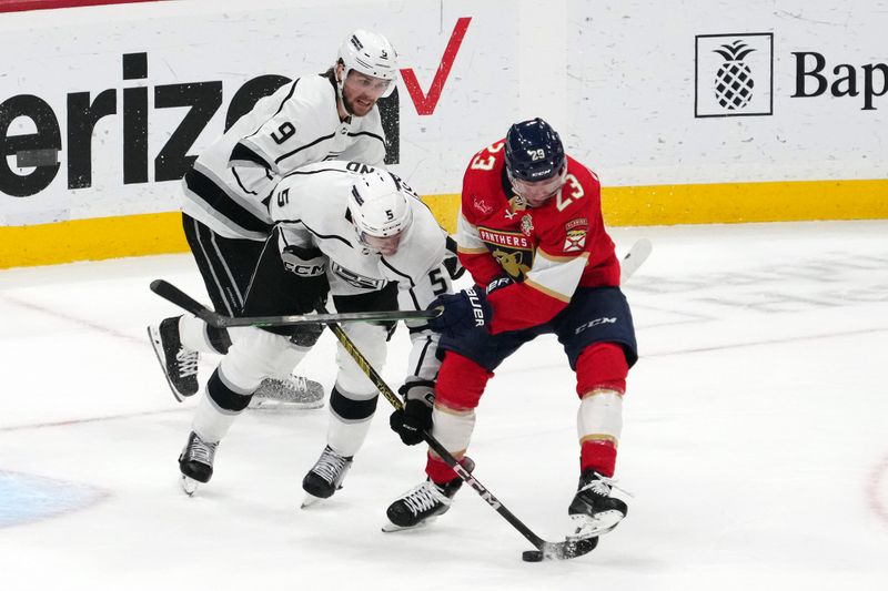 Jan 11, 2024; Sunrise, Florida, USA; Los Angeles Kings defenseman Andreas Englund (5) and Florida Panthers center Carter Verhaeghe (23) battle for the puck during the third period at Amerant Bank Arena. Mandatory Credit: Jasen Vinlove-USA TODAY Sports