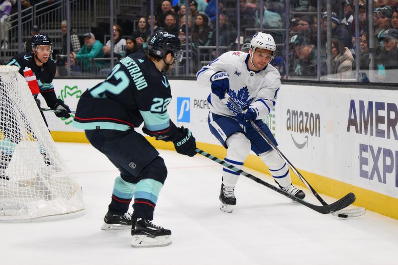 Jan 21, 2024; Seattle, Washington, USA; Toronto Maple Leafs center Max Domi (11) passes the puck past Seattle Kraken right wing Oliver Bjorkstrand (22) during the second period at Climate Pledge Arena. Mandatory Credit: Steven Bisig-USA TODAY Sports