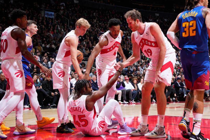 TORONTO, CANADA - OCTOBER 28: Toronto Raptors team help Davion Mitchell #45 off the ground on October 28, 2024 at the Scotiabank Arena in Toronto, Ontario, Canada.  NOTE TO USER: User expressly acknowledges and agrees that, by downloading and or using this Photograph, user is consenting to the terms and conditions of the Getty Images License Agreement.  Mandatory Copyright Notice: Copyright 2024 NBAE (Photo by Mark Blinch/NBAE via Getty Images)