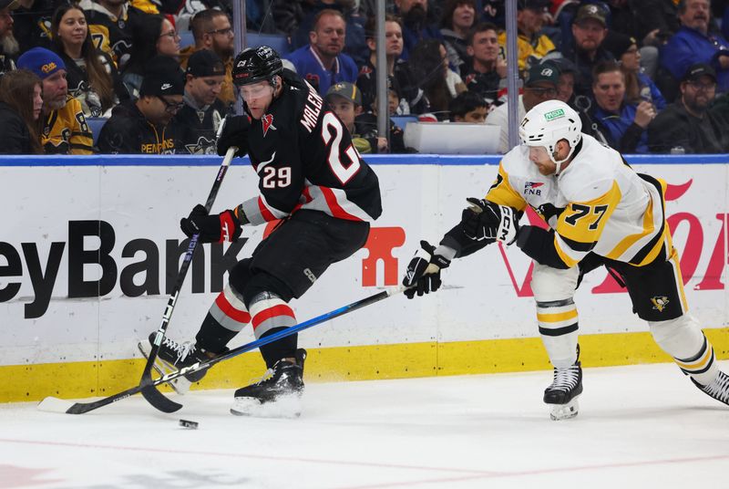 Feb 5, 2026; Buffalo, New York, USA;  Buffalo Sabres left wing Beck Malenstyn (29) makes a pass as Pittsburgh Penguins defenseman Brett Kulak (77) tries to block it during the second period at KeyBank Center. Mandatory Credit: Timothy T. Ludwig-Imagn Images