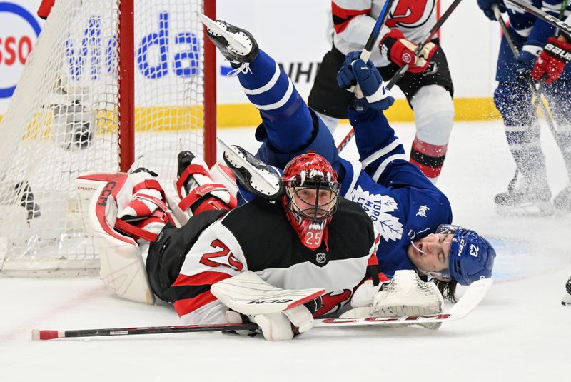 Jan 16, 2025; Toronto, Ontario, CAN;  New Jersey Devils goalie Jacob Markstrom (25) tracks the play after making a save on Toronto Maple Leafs forward Matthews Knies (23) in the first period at Scotiabank Arena. Mandatory Credit: Dan Hamilton-Imagn Images