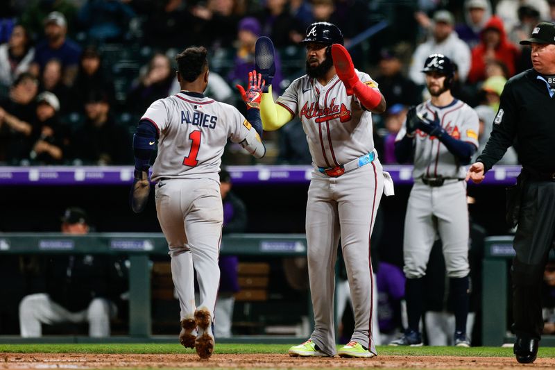 Apr 28, 2025; Denver, Colorado, USA; Atlanta Braves designated hitter Marcell Ozuna (20) celebrates with second baseman Ozzie Albies (1) after they were driven in on an RBI in the fifth inning against the Colorado Rockies at Coors Field. Mandatory Credit: Isaiah J. Downing-Imagn Images