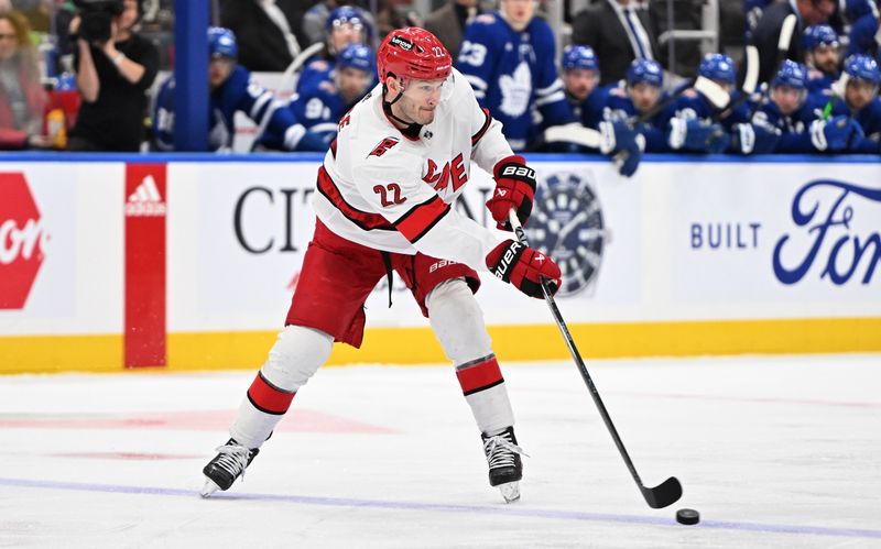 Dec 30, 2023; Toronto, Ontario, CAN; Carolina Hurricanes defenseman Brett Pesce (22) passes the puck in the second  period against the Toronto Maple Leafs at Scotiabank Arena. Mandatory Credit: Dan Hamilton-USA TODAY Sports