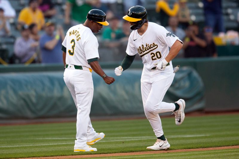 Jun 5, 2024; Oakland, California, USA; Oakland Athletics second baseman Zack Gelof (20) gets a congratulatory fist bump from Oakland Athletics third base coach Eric Martins (3) after hitting a solo home run against the Seattle Mariners during the third inning at Oakland-Alameda County Coliseum. Mandatory Credit: D. Ross Cameron-USA TODAY Sports