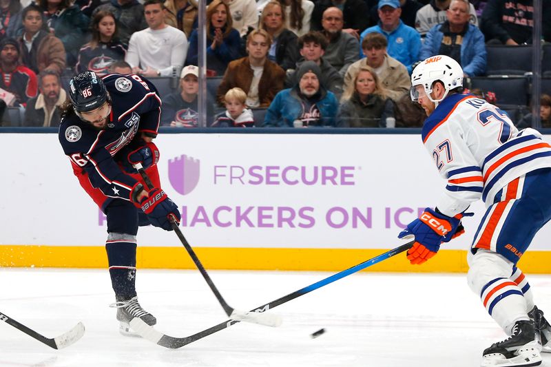 Nov 13, 2025; Columbus, Ohio, USA; Columbus Blue Jackets right wing Kirill Marchenko (86) shoots against Edmonton Oilers defenseman Brett Kulak (27) during the second period at Nationwide Arena. Mandatory Credit: Russell LaBounty-Imagn Images