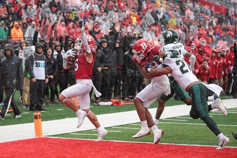 Oct 14, 2023; Piscataway, New Jersey, USA; Rutgers Scarlet Knights wide receiver Christian Dremel (6) scores a two point conversion as wide receiver Ian Strong (29) blocks Michigan State Spartans defensive back Dillon Tatum (21) during the second half at SHI Stadium. Mandatory Credit: Vincent Carchietta-USA TODAY Sports