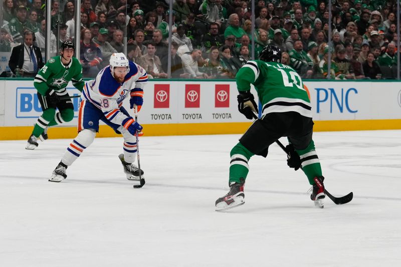 Feb 17, 2024; Dallas, Texas, USA; Edmonton Oilers center Connor Brown (28) controls the puck against Dallas Stars center Tyler Dellandrea (10) during the first period at American Airlines Center. Mandatory Credit: Chris Jones-USA TODAY Sports