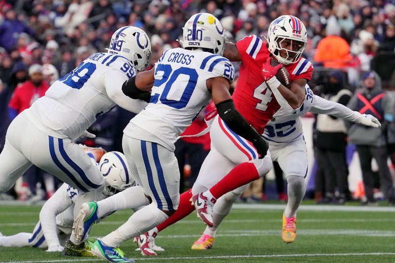 New England Patriots running back Antonio Gibson (4) carries for a touchdown against Indianapolis Colts defensive tackle DeForest Buckner (99) and safety Nick Cross (20) during the second half of an NFL football game, Sunday, Dec. 1, 2024, in Foxborough, Mass. (AP Photo/Steven Senne)