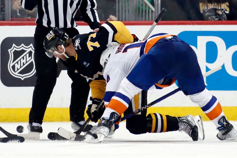 Mar 9, 2023; Pittsburgh, Pennsylvania, USA;  Pittsburgh Penguins center Jeff Carter (77) and New York Islanders center Bo Horvat (14) battle to control the puck on a face-off during the third period at PPG Paints Arena. The Islanders won 4-3 in overtime. Mandatory Credit: Charles LeClaire-USA TODAY Sports