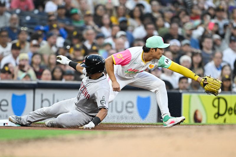 July 5, 2024; San Diego, California, USA; Arizona Diamondbacks catcher Gabriel Moreno (14) slides into third base ahead of throw to San Diego Padres shortstop Ha-Seong Kim (7) during the fourth inning at Petco Park. Mandatory Credit: Denis Poroy-USA TODAY 